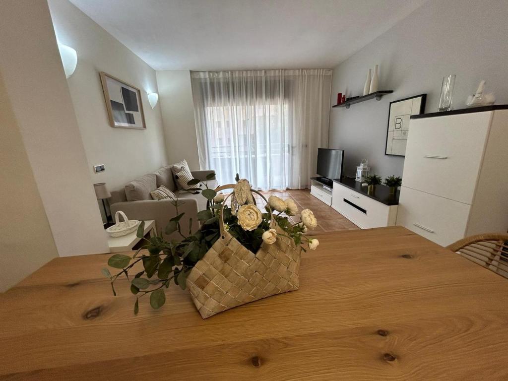a living room with a table with flowers on it at Apartamentos LOS TULIPANES in Salou