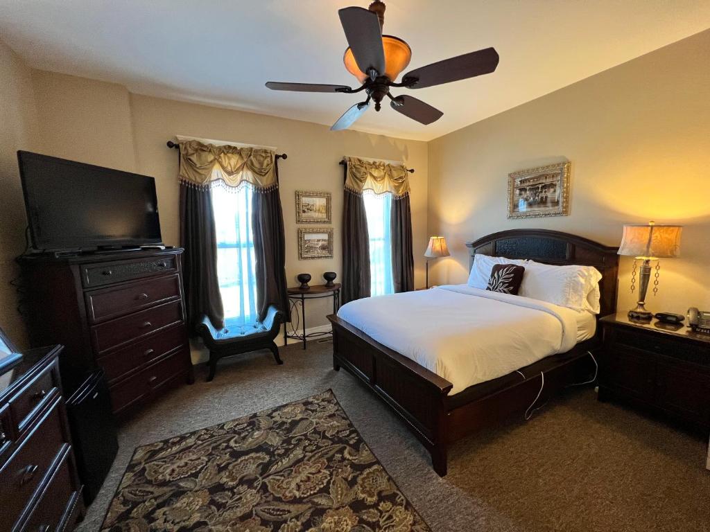 a bedroom with a bed and a ceiling fan at Historic Branson Hotel - Heritage Room with Queen Bed - Downtown - FREE TICKETS INCLUDED in Branson