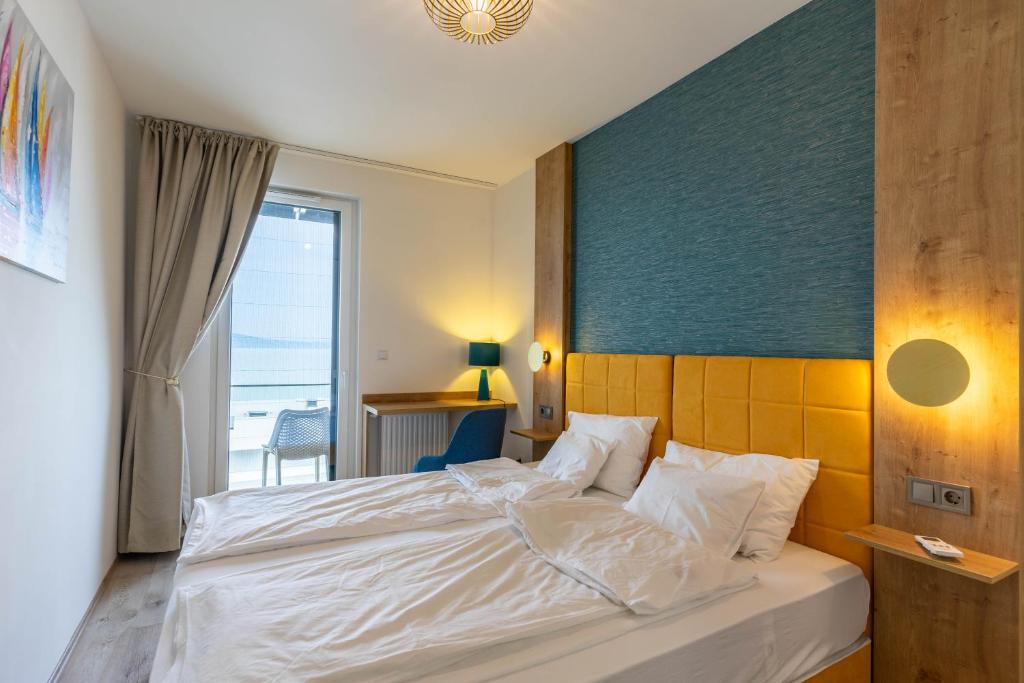 a bedroom with a white bed with a view of the ocean at Apartment at the Lake and view in Fonyód