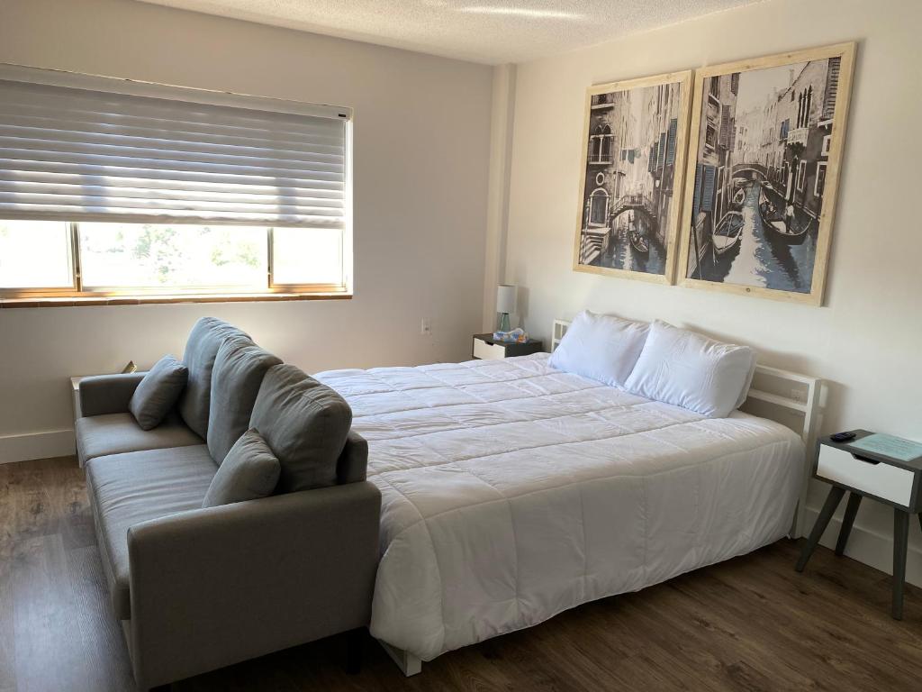 - une chambre avec un grand lit et un canapé dans l'établissement Innovative Studio Apartment, à Gadsden