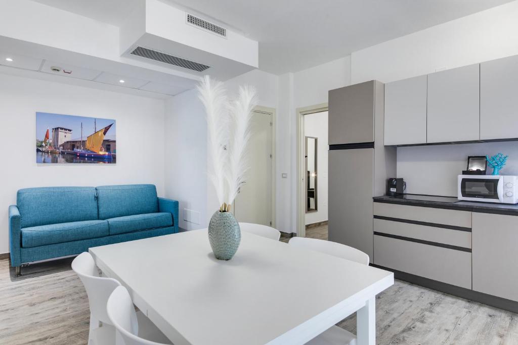 a living room with a white table and a blue couch at Elegance Suite Apartments in Cervia