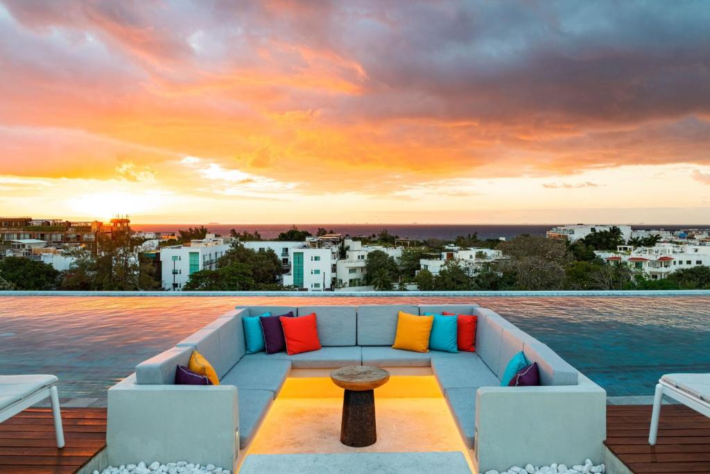 un sofá en una terraza con vistas al agua en Aloft Playa del Carmen en Playa del Carmen