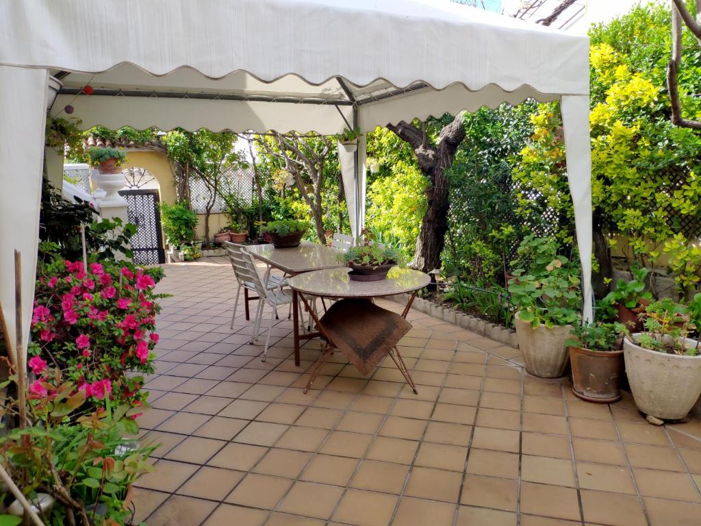een patio met een tafel en een witte parasol bij Chalet en Valle del Tietar in Lanzahita