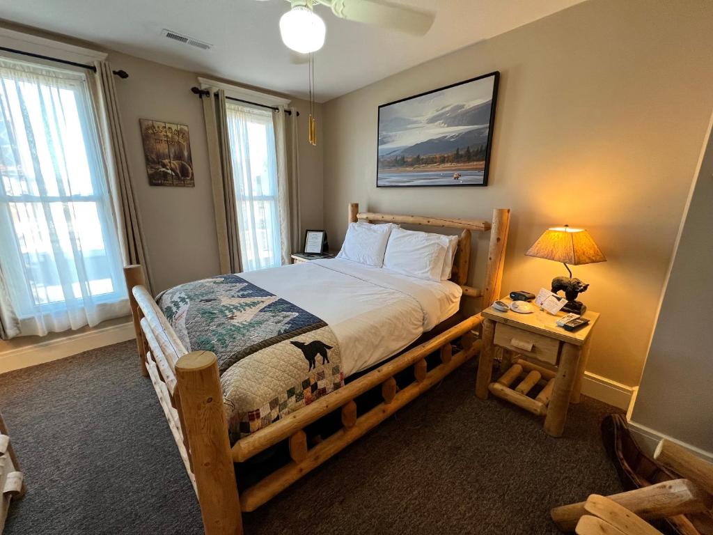 um quarto com uma cama de madeira e uma mesa com um candeeiro em Historic Branson Hotel - Hide-A-Way Room with Queen Bed - Downtown - FREE TICKETS INCLUDED em Branson
