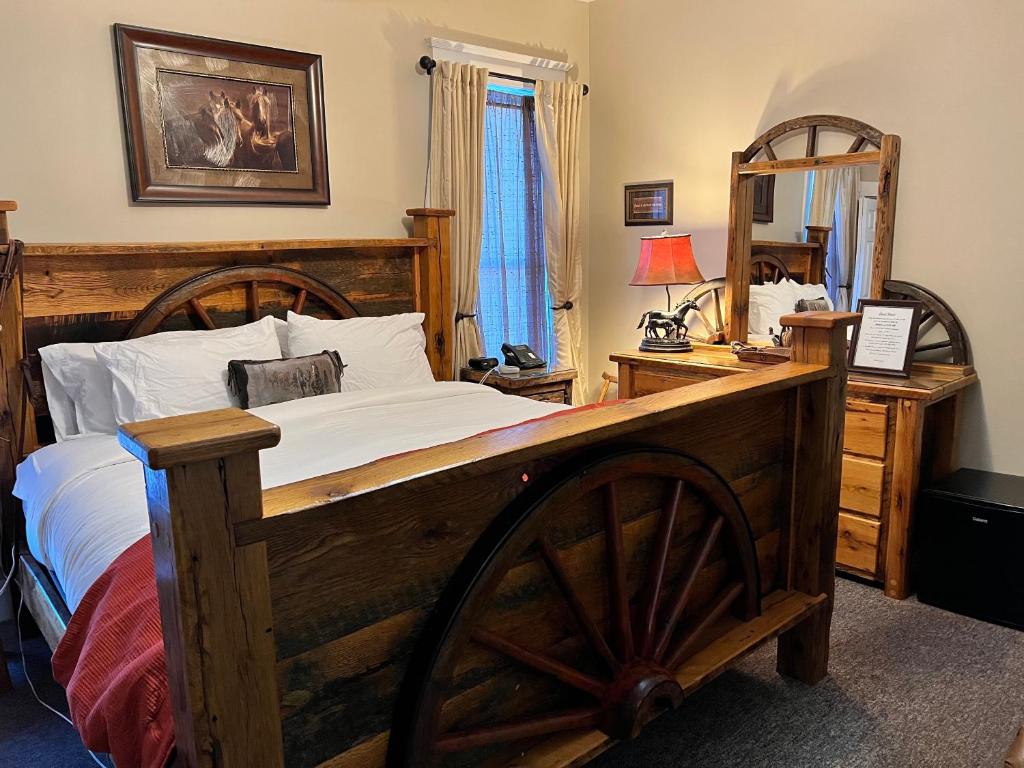 um quarto com uma grande cama de madeira e um espelho em Historic Branson Hotel - Horseshoe Room with King Bed - Downtown - FREE TICKETS INCLUDED em Branson
