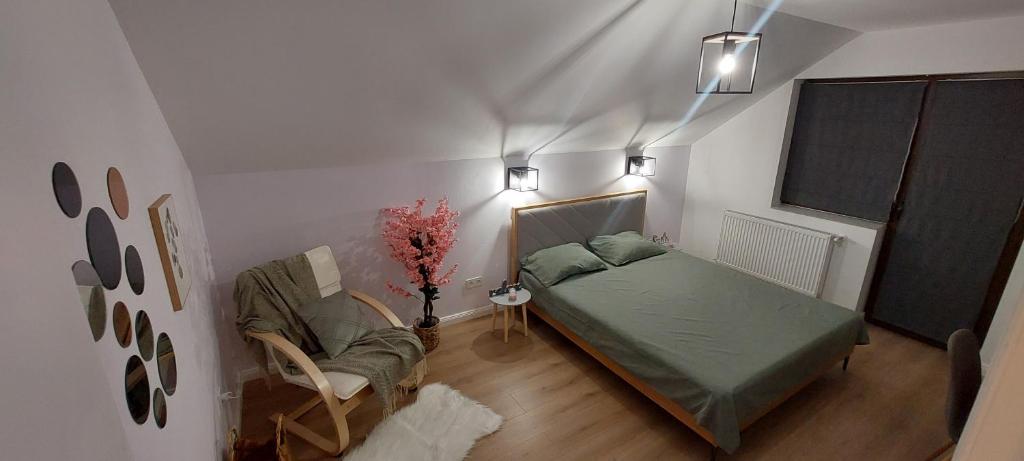 a bedroom with a bed and a chair in a room at Matei Apartments in Baia Mare