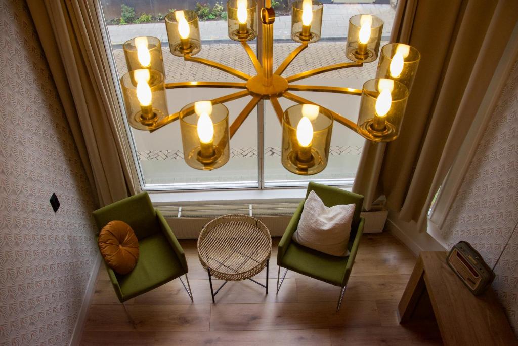 a chandelier in a room with chairs and a window at Drostenstraat 5 in Zwolle