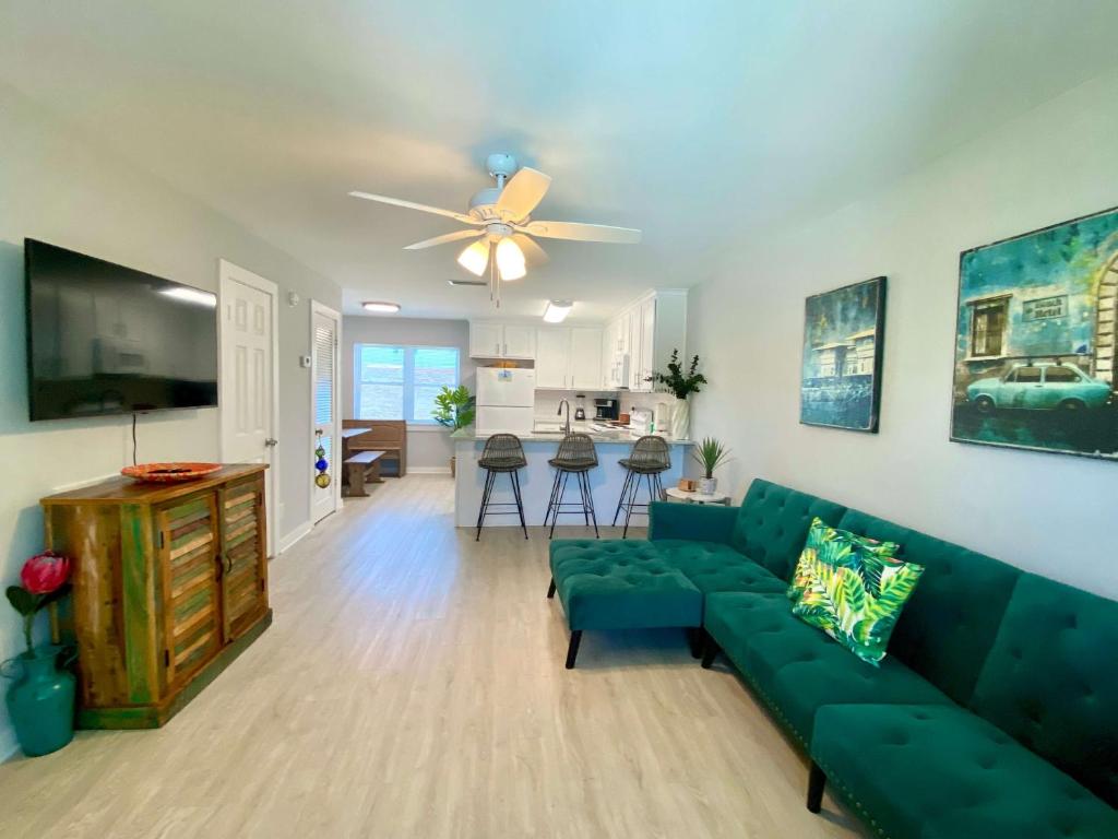 uma sala de estar com um sofá verde e uma ventoinha de tecto em Sand Dollar 2 by ALBVR - Walking distance to Hangout! Beautifully redone condo! em Gulf Shores