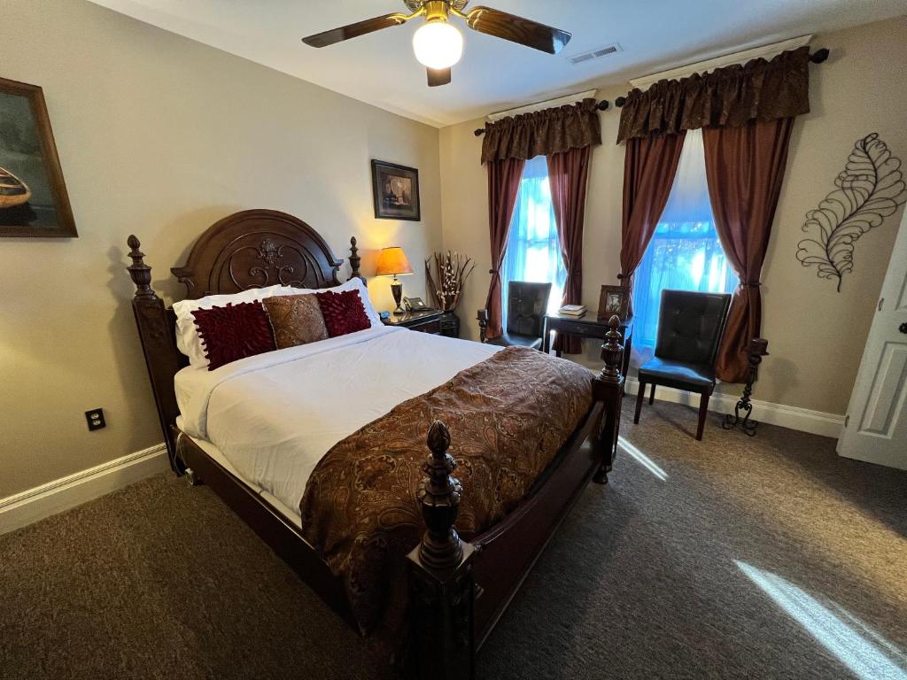 a bedroom with a bed and a ceiling fan at Historic Branson Hotel - Notebook Room with Queen Bed - Downtown - FREE TICKETS INCLUDED in Branson