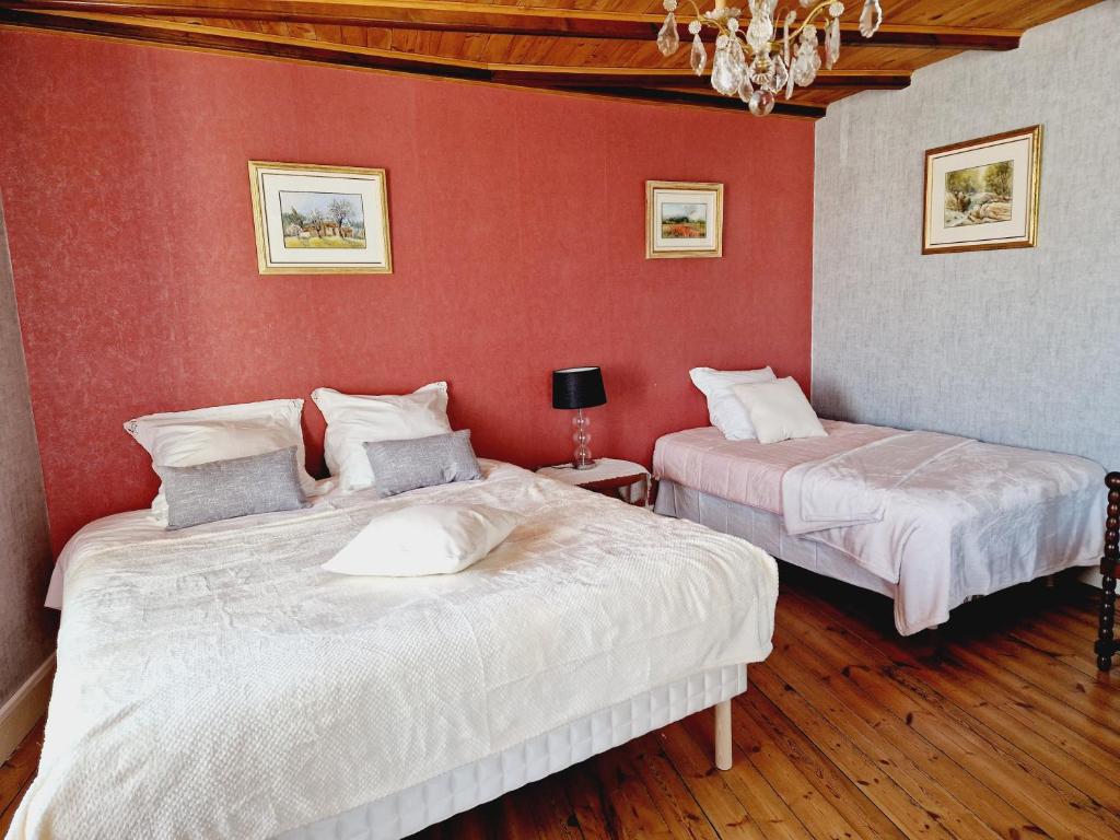 two beds in a room with red walls at Chez Sarah - L'Amaryllis in Javerlhac-et-la-Chapelle-Saint-Robert