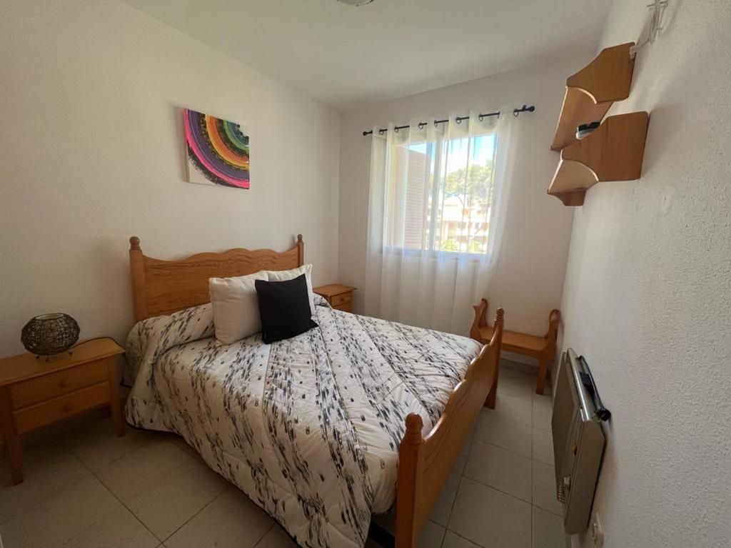 a bedroom with a bed and a window at Residencial Alcanar Costa in Alcanar