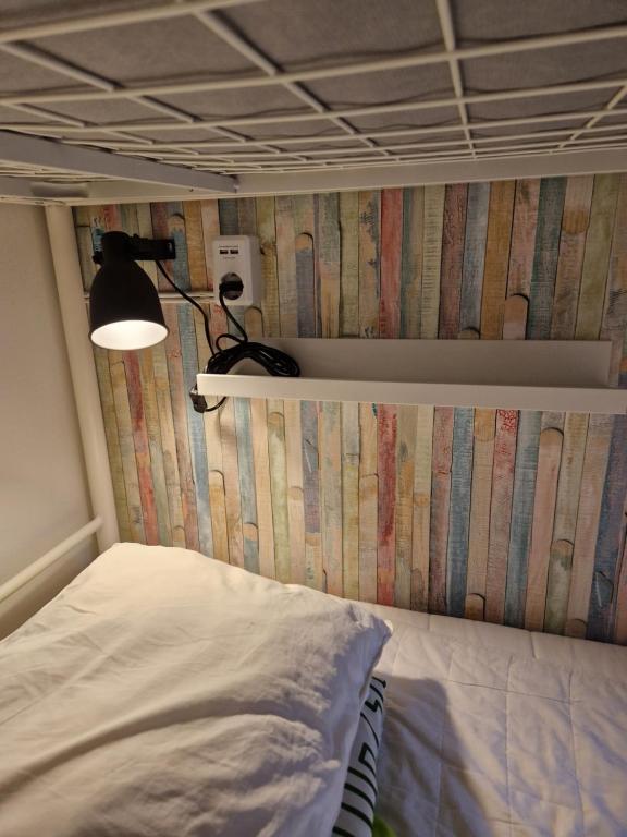 Crafoord Place Hostel في ستوكهولم: غرفة نوم عليها سرير ومصباح