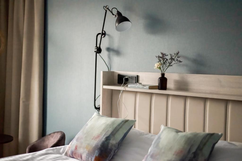 a bedroom with a bed with a lamp and a pillow at Hotell Nissastigen in Gislaved