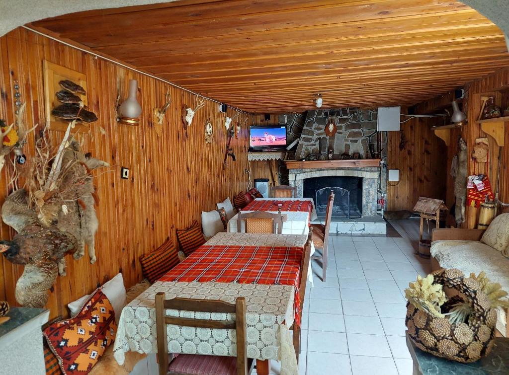 uma sala de estar com uma mesa e uma lareira em Къща за гости Иглика em Trigrad