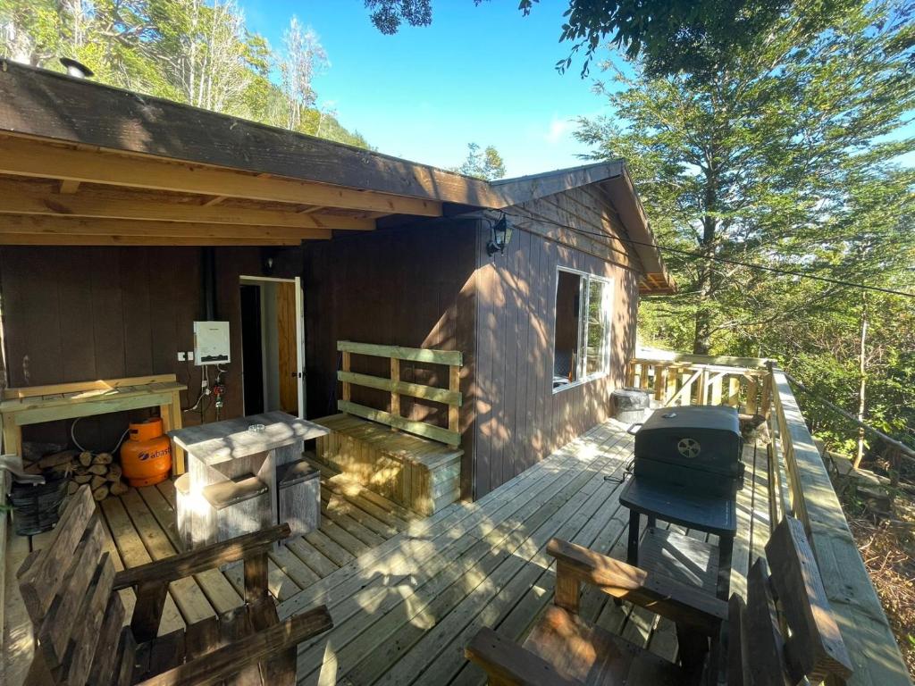 a porch of a wooden cabin with a grill at El Chiflon Un Lugar de Ensueño in Puerto Rico