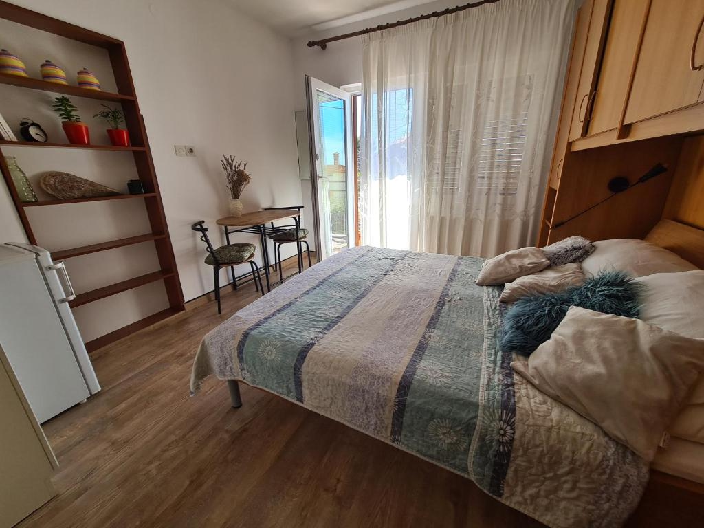 Schlafzimmer mit einem Bett, einem Tisch und einem Fenster in der Unterkunft Apartments Ada in Rovinj