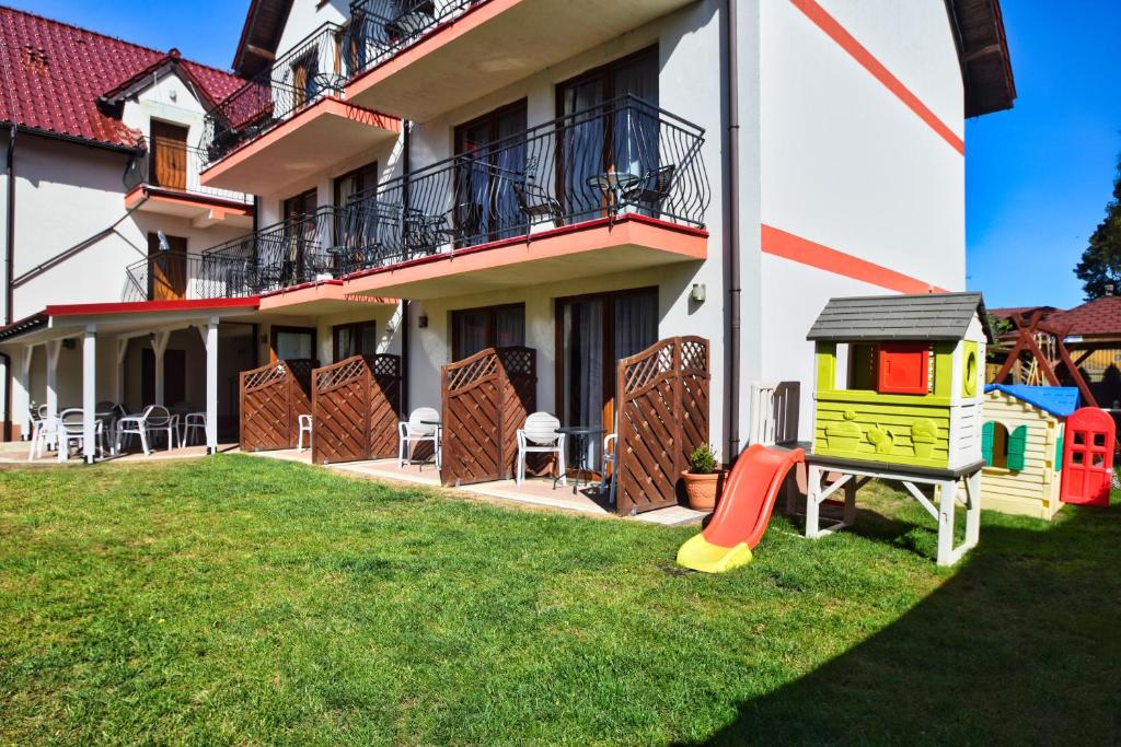 a house with a playground in the yard at Dafne 2 in Niechorze