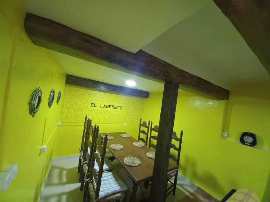 un comedor con una mesa en una habitación amarilla en El Laberinto, en Sotillo de la Adrada