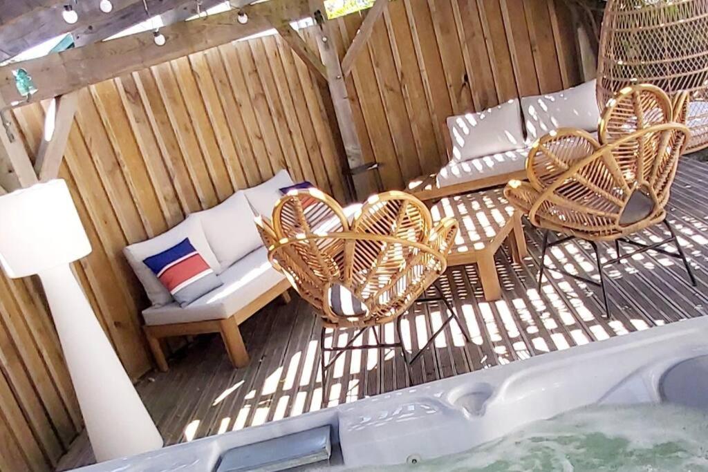 un patio con due sedie, una panca e un divano di La Maison Tchanquée jusqu'à 12 personnes Jacuzzi privé a Gujan-Mestras