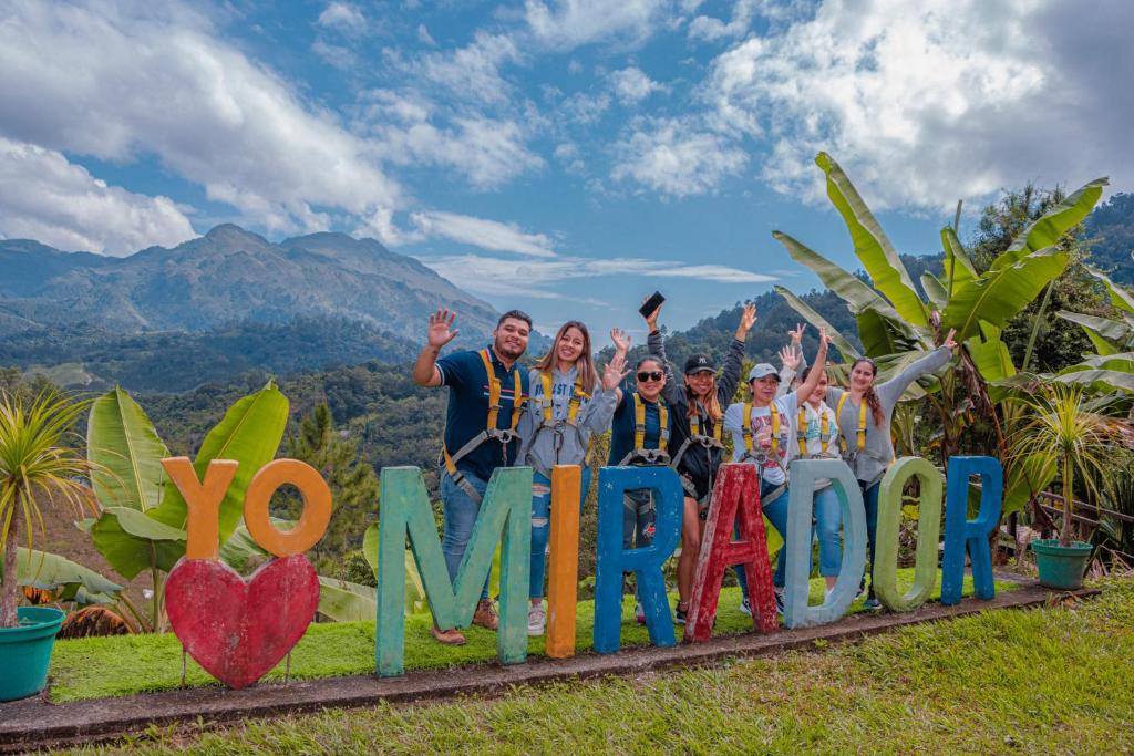 Un groupe de personnes se tenant derrière un signe qui dit que vous vous mariez dans l'établissement El Mirador de Tansu, à Lanquín