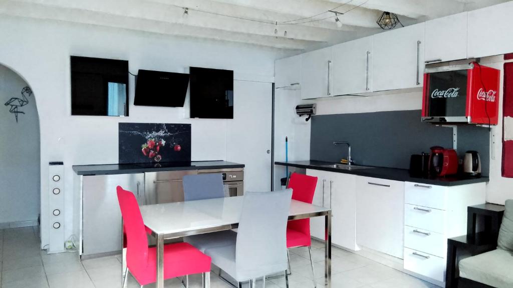 une cuisine avec une table à manger et des chaises rouges dans l'établissement Maison de ville centre arles, à Arles