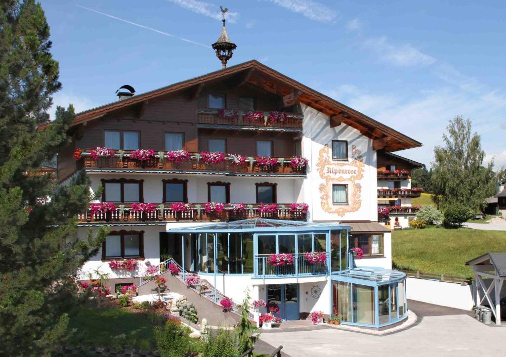 ein großes Gebäude mit Blumen auf den Balkonen in der Unterkunft Sportpension Alpenrose in Schladming