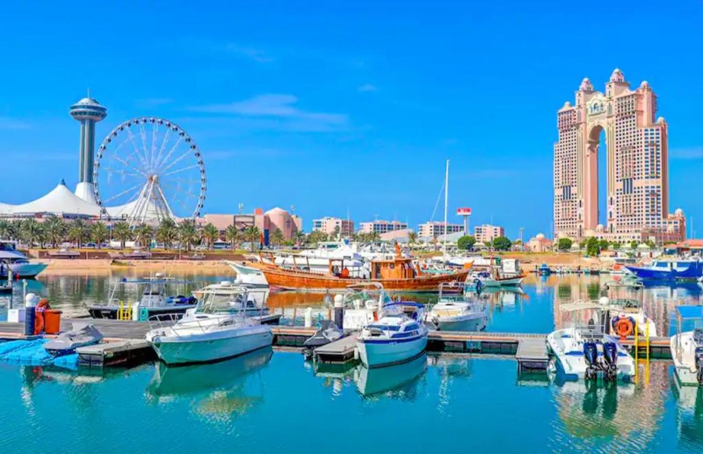 a group of boats docked in a harbor with a ferris wheel at Phenomenal Room "Sea View" in Abu Dhabi