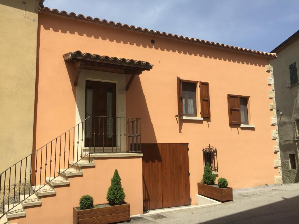 Casa grande de color naranja con puerta de madera en Mo.Da' Apartments, en San Marino