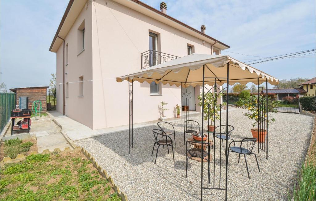 un patio con mesa, sillas y sombrilla en Casa Pra Bene Vagienna, en Bene Vagienna