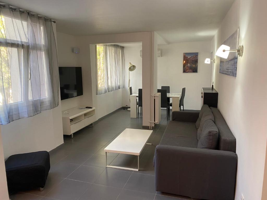 salon z kanapą i stołem w obiekcie Appartement proche centre ville w Aix-en-Provence