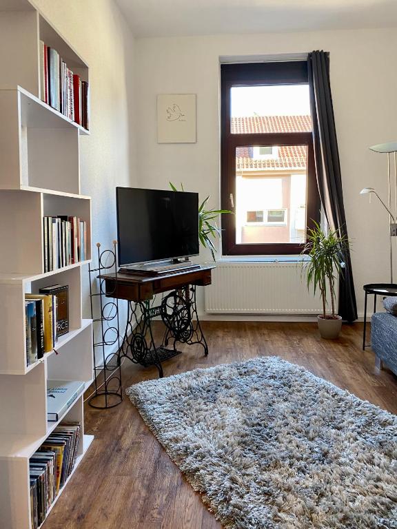 a living room with a tv and a table and a rug at Entspannt Mittendrin in Hannover