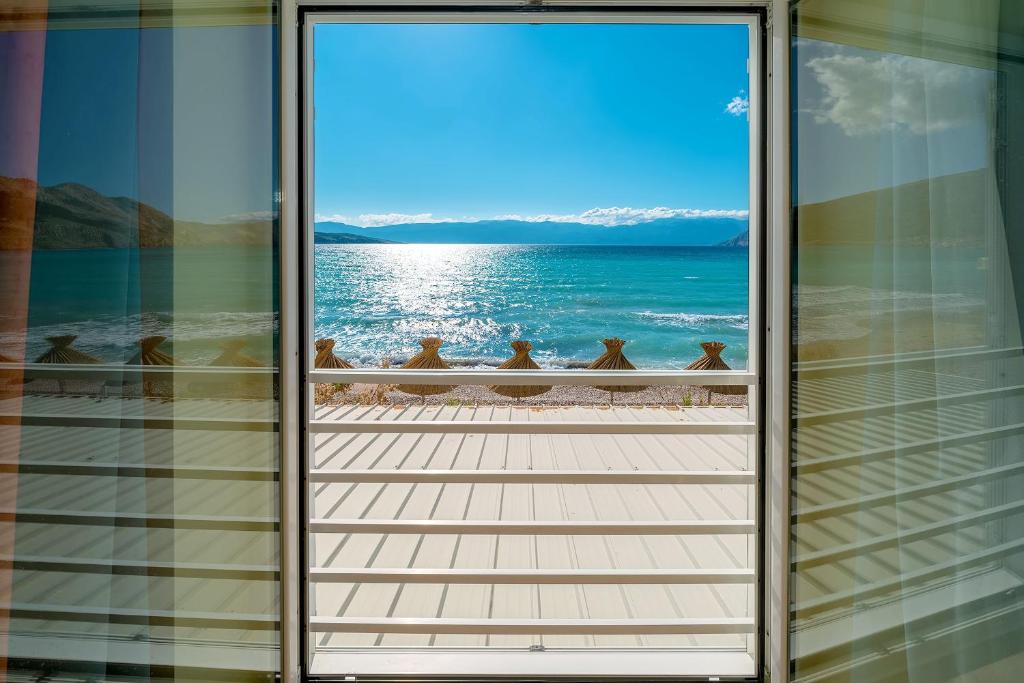 a group of birds sitting on a balcony overlooking the ocean at Hotel Dobrovit in Baška