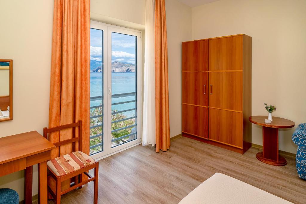 a living room with a large window with a view of the ocean at Hotel Dobrovit in Baška