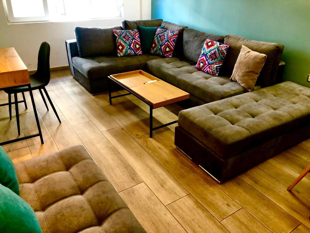 ein Wohnzimmer mit einem Sofa und einem Couchtisch in der Unterkunft Royal Blue Grand Suite No 1 in Piräus