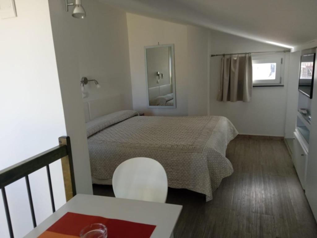 een kleine slaapkamer met een bed en een witte stoel bij B&B San Michele in Piano di Sorrento