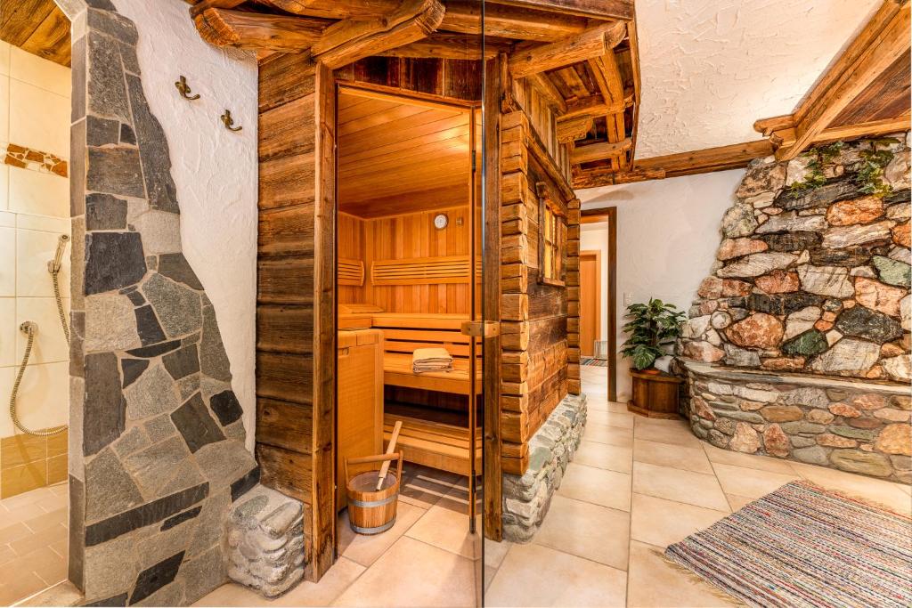 baño con paredes de madera y pared de piedra. en Appartement Oberschernthann en Hopfgarten im Brixental