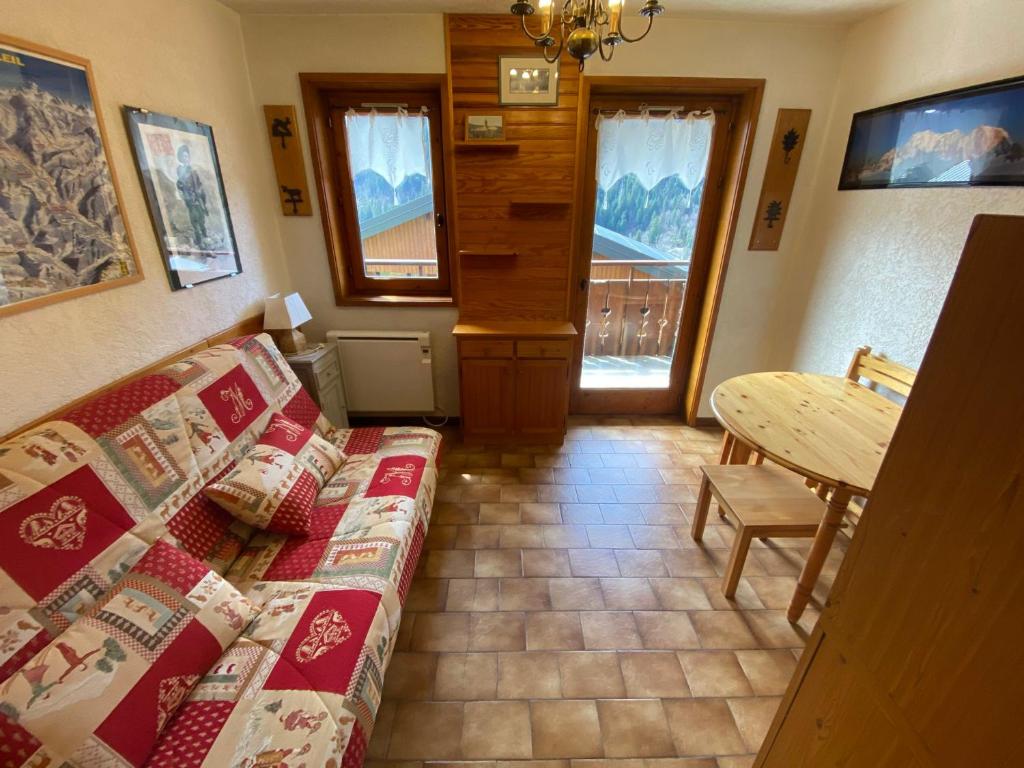 a living room with a couch and a table at Chaleureux studio avec balcon Sud/Ouest à 500m du centre, parking et à deux pas des remontées! - FR-1-693-54 in Châtel