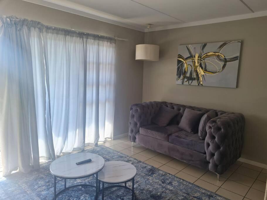a living room with a couch and a table at Tripleg Apartments 1 in Fourways