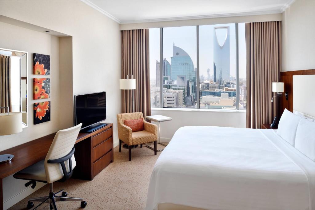 een hotelkamer met een bed, een bureau en een raam bij Courtyard by Marriott Riyadh Olaya in Riyad