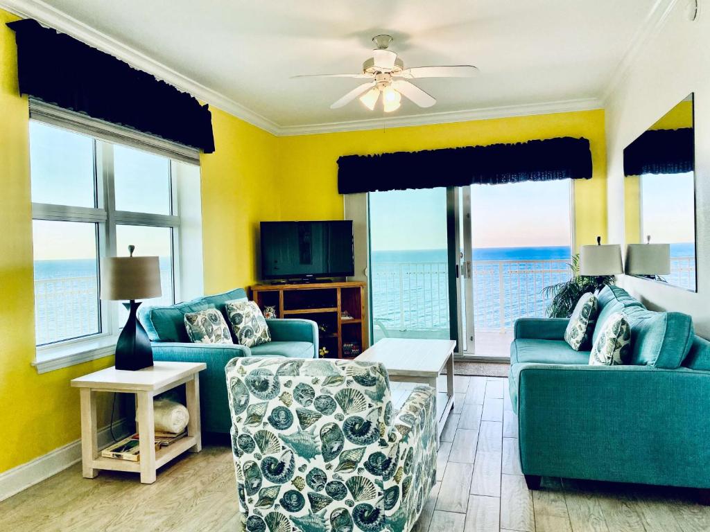 a living room with two blue couches and a television at Crystal Shores 1301 by ALBVR - Beautiful Beachfront Corner Condo with Gorgeous Views! in Gulf Shores
