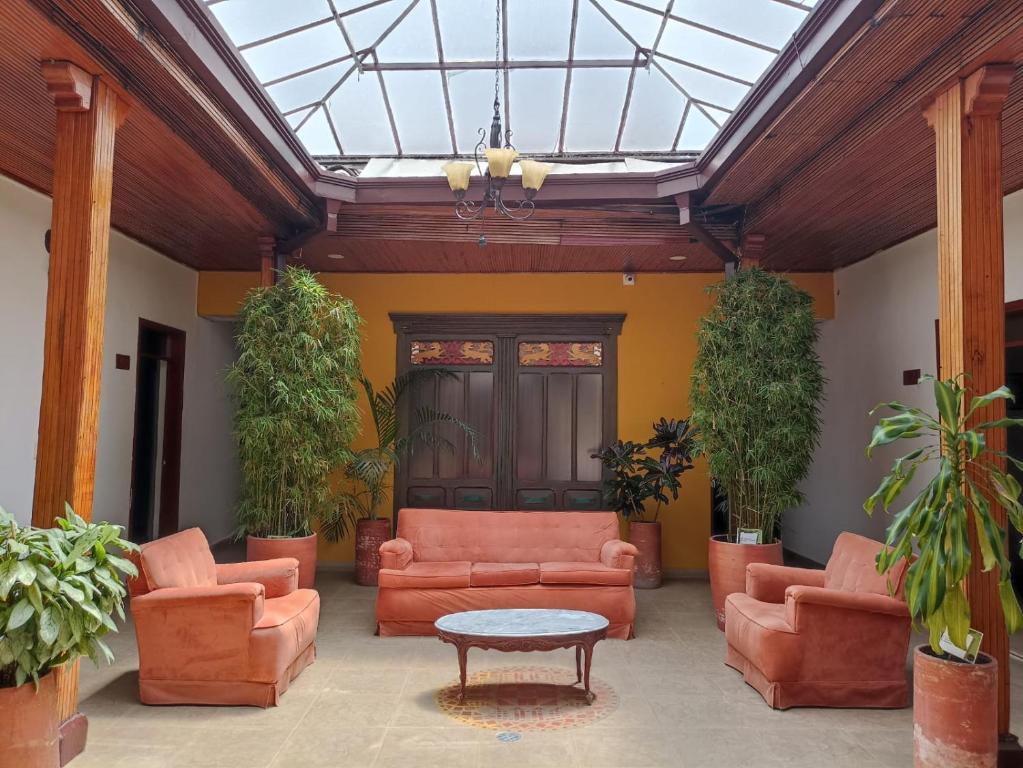 Elle comprend un salon doté d'un mobilier orange et d'un plafond en verre. dans l'établissement Hotel Plaza Mayor, à Duitama