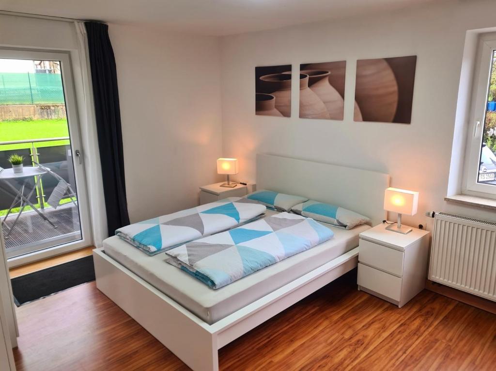 1 dormitorio con 1 cama con 2 lámparas y una ventana en Ferienwohnung Steigerwald Gerolzhofen en Gerolzhofen