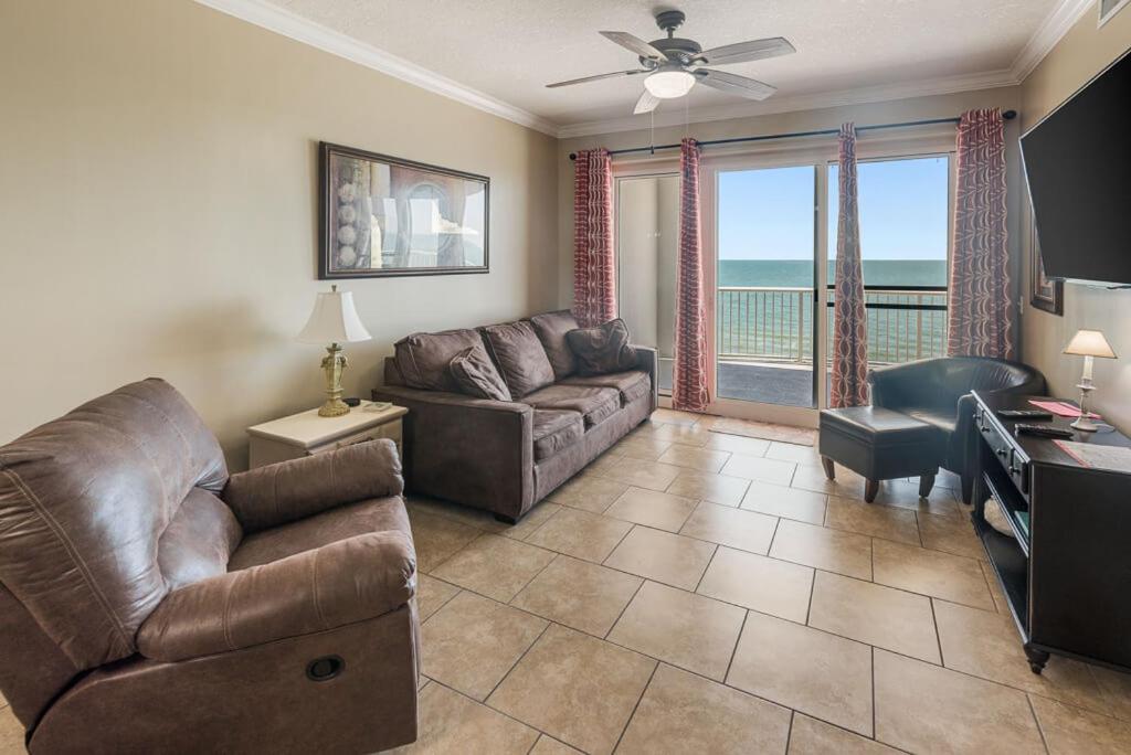 uma sala de estar com um sofá, uma cadeira e uma mesa em Island Royale 1002 by ALBVR - Come & relax at our beautiful beachfront condo in the heart of Gulf Shores! em Gulf Shores