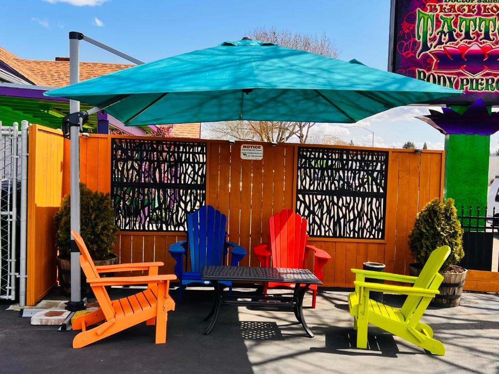 a group of colorful chairs sitting under an umbrella at Signature Inn Eugene in Eugene