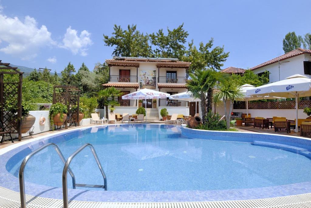 une grande piscine en face d'une maison dans l'établissement Enalion Hotel, à Kala Nera