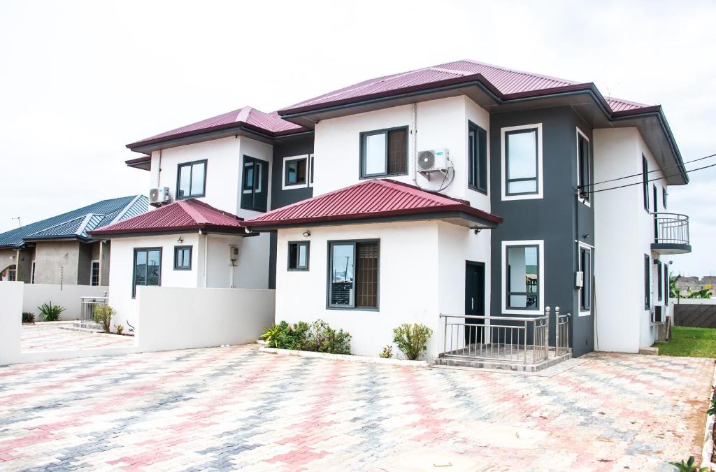una casa con tetti rossi e un vialetto di THE GRANGE HOTEL GHANA a Dawhwenya