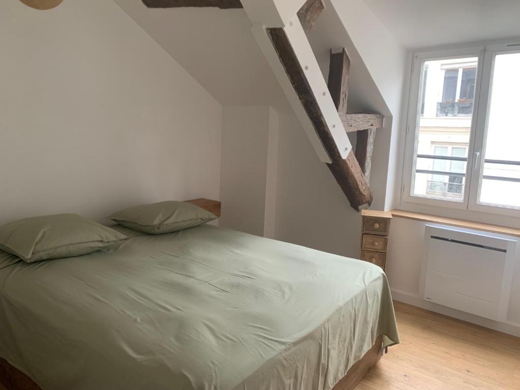 ein Schlafzimmer mit einem Bett und einem Treppenaufgang in der Unterkunft Paris - Notre Dame - Panthéon - Luxembourg - 30 m2 in Paris