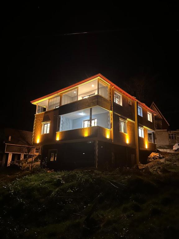 Una casa se ilumina por la noche en Pocibükensarayları en Çamlıhemşin