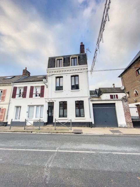 un bâtiment blanc au bord d'une rue dans l'établissement Maison avec 4 chambres au centre de st Valéry, à Saint-Valery-sur-Somme