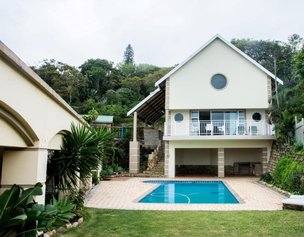 a house with a swimming pool in front of it at Ocean Breeze Beach House in Port Shepstone
